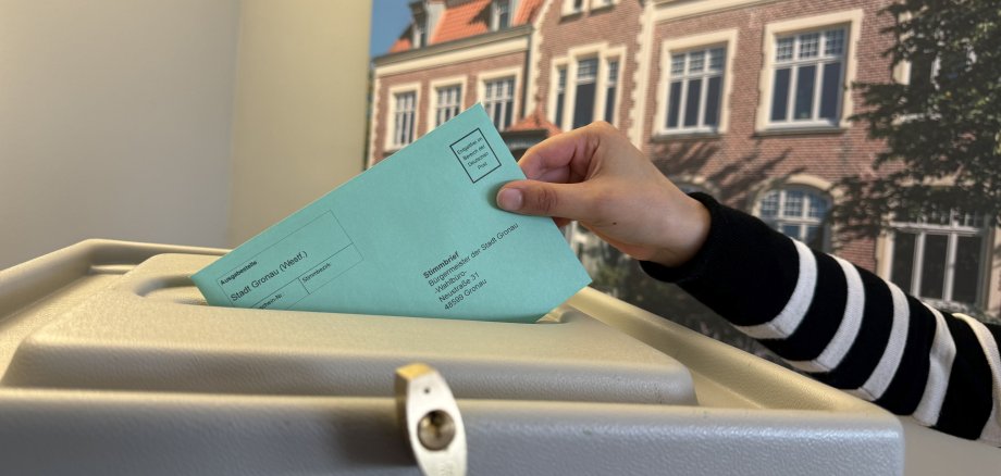 Ein Wahlbrief wird in Wahlurne gesteckt