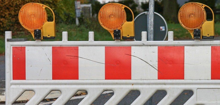 Eine Baustellenabsperrung steht auf einer Straße.