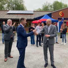 Der Bürgermeister der Gemeente Enschede, Roelof Bleker, übergibt das Friedensfeuer an den Bürgermeister der Stadt Gronau, Rainer Doetkotte.