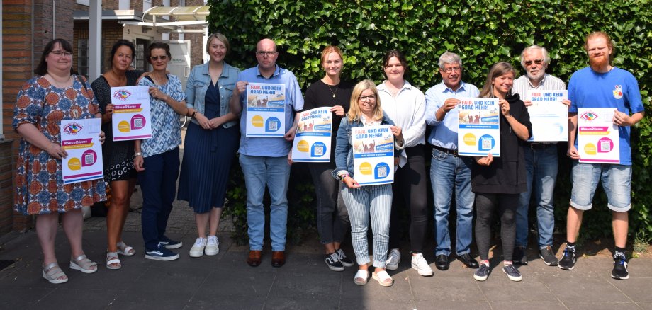 Die Steuerungsgruppe Fairtrade Gronau mit dem Poster zur Fairen Woche 2024.