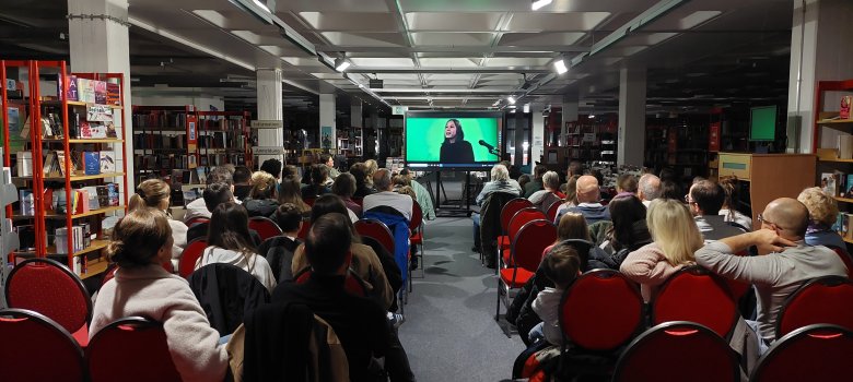 Familienmitglieder und Freund:innen schauen den Film "Screamy Brithday" in der Stadtbücherei.