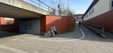 Ein Radfahrer fährt die Rampe herunter und biegt vorsichtig um die Kurve in der Bahnhofunterführung in Gronau