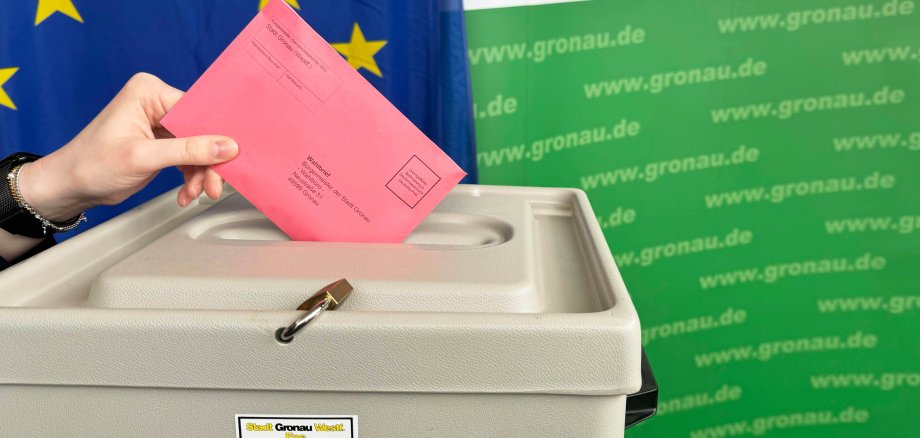 Ein roter Wahlbrief für die Europarwahl wird in eine Wahlurne geworfen.