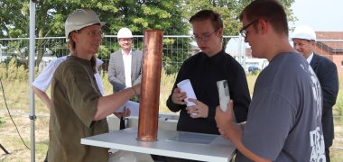 Architektin Heike Lau mit zwei Schülern und der Zeitkapsel